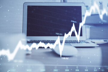 Stock market chart hologram drawn on personal computer background. Multi exposure. Concept of investment.