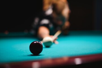 the player takes aim at the ball in Billiards