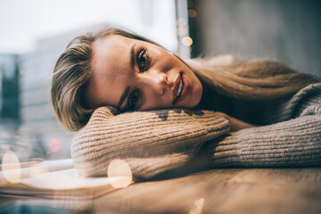 Wall Mural - Close up portrait of pretty Caucasian hipster girl 20 years old enjoying resting time for thinking, charming female teenager with perfect skin looking at camera while recreation in soft focus