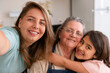 © Vergani Fotografia - Portrait of brazilian grandmother, mother and granddaughter with big smile looking at camera in kitchen home, indoors. Family, bonding, love, multi generation concept..