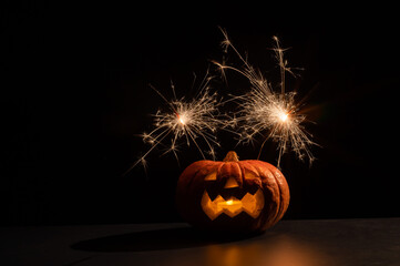 Wall Mural - Halloween pumpkin with scary carved grimace and sparklers.