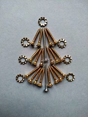 Christmas tree built of construction screws on a blue background.