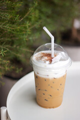 Wall Mural - Ice cappuccino in plastic cup on white table.