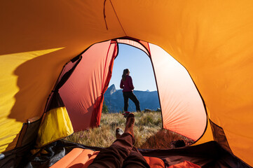 Fototapete - Relaxing at the tent in the mountains during a summers sunrise.