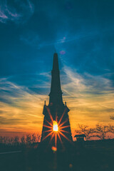 Vertical shot of a silhouetted building against the sunset sky