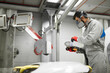 © Roman - young male in full body uniform preparing polisher machine for work. side view