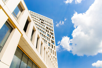 Wall Mural - office building exterior outdoor facade architecture side landmark photography foreshortening from below on vivid blue sky white clouds background