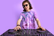 © Roman - caucasian stylish dj man in sunglasses mixing console on purple studio background, perform dance club music. portrait