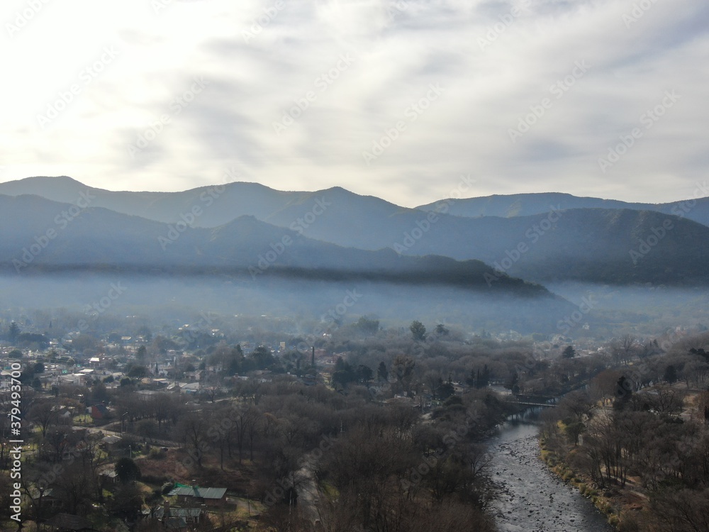Vista aérea panorámica de un pueblo en un valle con montañas al fondo ...