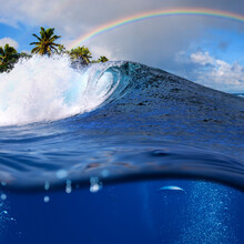 Perfect Tropical Ocean View Splitted By Waterline To Two Part. Shorebreak  Breaking Surfing Wave. Palms And Clouds In Daylight With Colorful Rainbow.