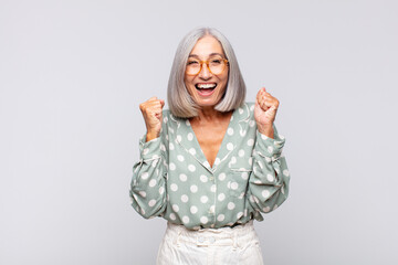 Wall Mural - gray haired woman feeling shocked, excited and happy, laughing and celebrating success, saying wow!