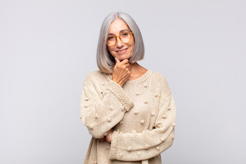 Wall Mural - gray haired woman smiling, enjoying life, feeling happy, friendly, satisfied and carefree with hand on chin