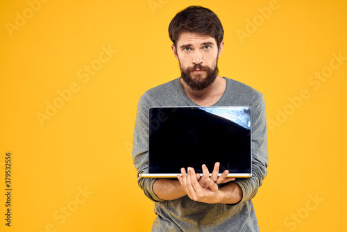 Fotografía man with laptop wireless technology internet lifestyle work yellow isolated back
