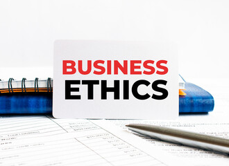 Poster - business card with text business ethics lying on blue notebook