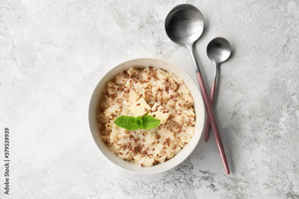 Bowl with tasty sweet oatmeal on light background