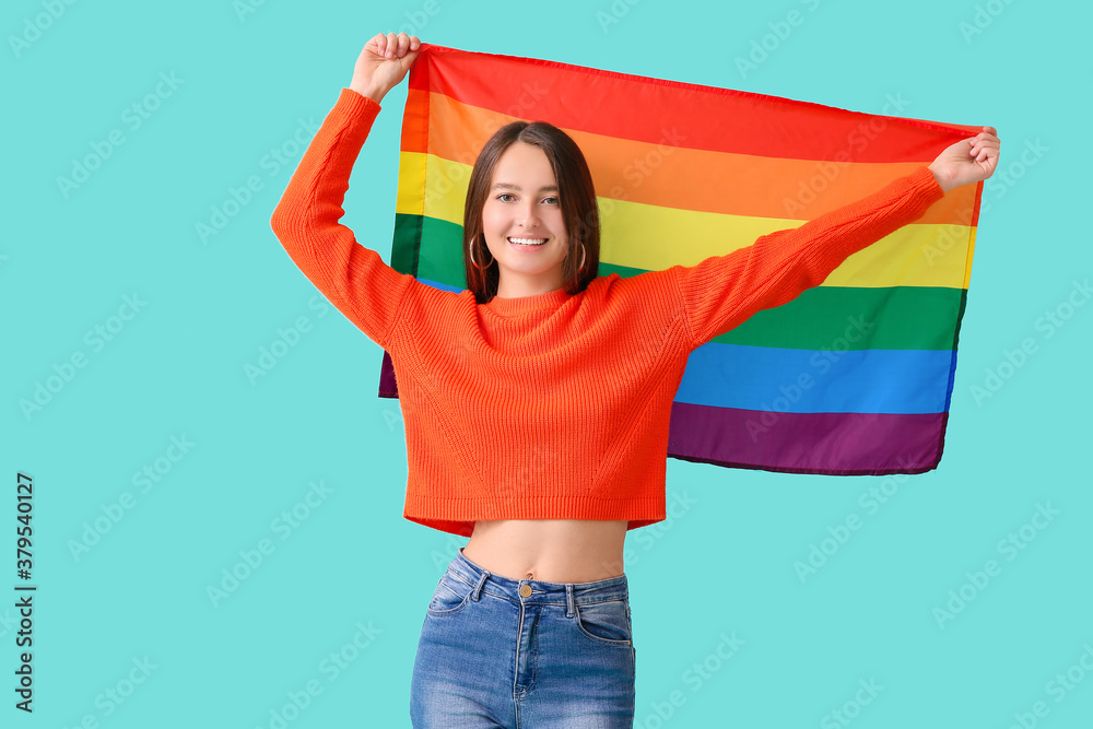 Young woman with LGBT flag on color background