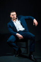 Handsome young business man in a studio wearing a suit. Fashionable European businessman in perfect suite.