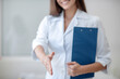 © zinkevych - Pretty doctor in a lab coat smiling and welcoming the patient