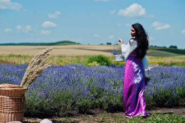 Beautiful indian girl wear saree india traditional dress in purple lavender field with basket.