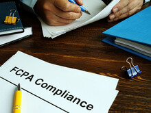 The US Foreign Corrupt Practices Act. FCPA Compliance Guide On The Desk.