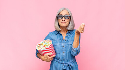 middle age woman making capice or money gesture, telling you to pay your debts! movie concept