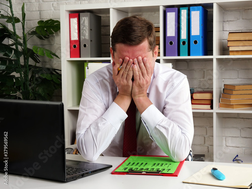 Cuadros en Lienzo Tired and pensive businessman covered his face with his hands while reading the audit results