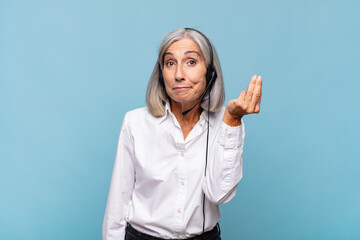 Wall Mural - middle age woman making capice or money gesture, telling you to pay your debts!. telemarketer concept