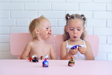 Two little girls eating candy