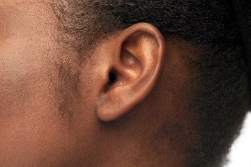 hearing, health and beauty concept - close up of african american woman's ear