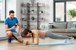 © Syda Productions - fitness, sport, training and lifestyle concept - happy smiling personal trainer with smartphone and woman doing plank at home