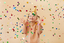 Waist Up Portrait Of Excited Girl With Down Syndrome Smiling Happily While Standing Under Confetti Shower In Studio, Copy Space