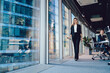 © BullRun - Cheerful elegant businesswoman walking with tablet in boardroom