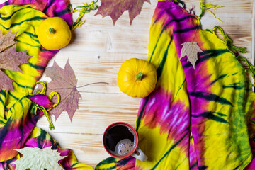 Poster - Colorful autumn still life with cup of coffee, pampkins, fallen maple leaves and yellow with red shawl