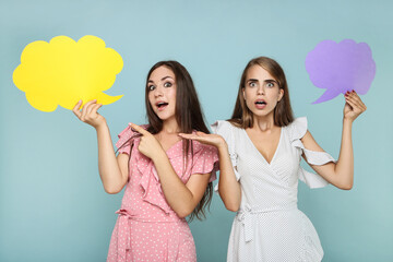 Poster - Young happy girlfriends with paper speech bubbles on grey background