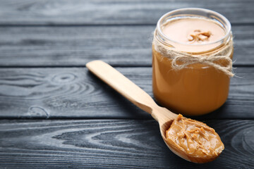 Poster - Peanut butter in glass jar with spoon on black wooden table