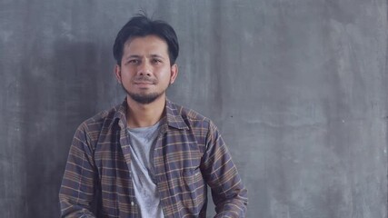 Wall Mural - Asian male construction worker Wearing a yellow helmet on Cement wall background slow motion