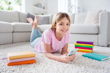 Canvas Print - Full body photo of positive kid girl lying floor carpet use cellphone enjoy social media communication conversation repost subscribe in house indoors