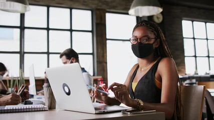 Wall Mural - Young business people with face masks working indoors in office, coronavirus concept.