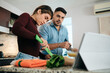 © Diego Cervo - Couple Cooking Together Watching Tutorial For Recipe