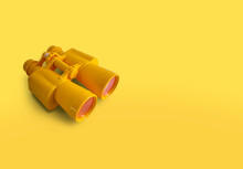 Yellow Binoculars Isolated On Yellow Background With Copy Space	
