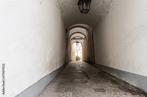 Fotomural Narrow inner paved stone urban street road passage in old european city