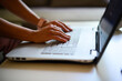 © Minerva Studio - Closeup of a woman typing on a laptop keyboard