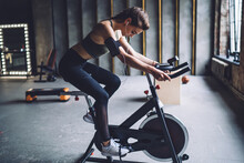 Young Athletic Woman Spinning On Exercise Bicycle