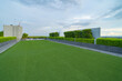 © tampatra - Sky garden on private rooftop of condominium or hotel, high rise architecture building with tree, grass field, and blue sky.