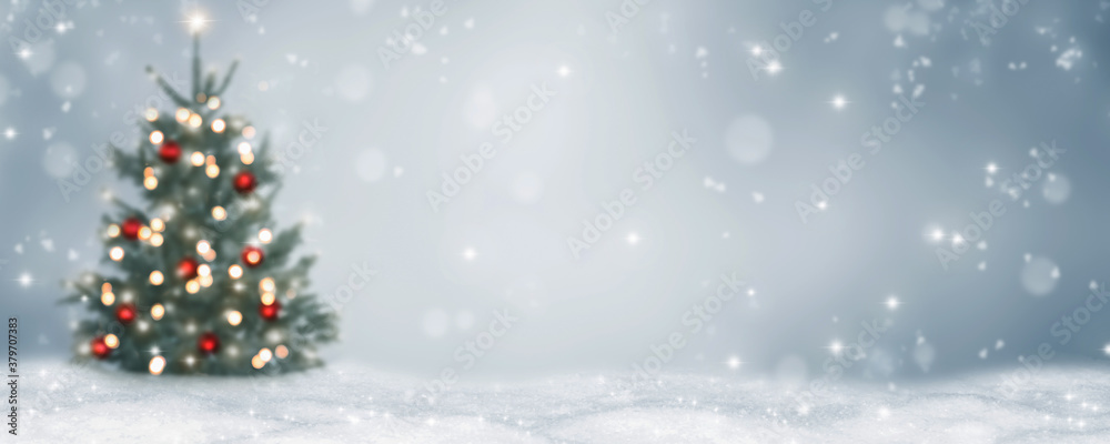 blurred christmas tree and lights on abstract white snow landscape ...