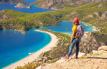 Poster - Sporty hiking girl over Oludeniz lagoon in sea landscape view of beach, Turkey. Travel and healthy lifestyle