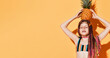 © FAB.1 - Teenage girl with african pigtails, in colorful swimwear. She closed eyes, holding pineapple on head, posing on yellow background