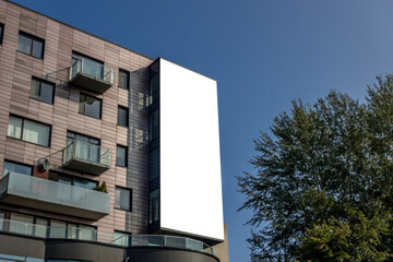 Wall Mural - Mock up. Big blank white billboard on the facade of modern highrise building in the city