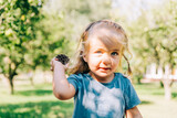 Fototapeta Kwiaty - Toddler girl portrait in garden