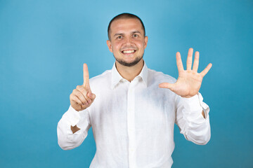 Russian business man over blue background showing and pointing up with fingers number six five while smiling confident and happy.